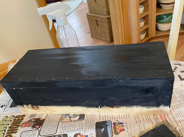 Photo of a pine wooden box being paint with black chalk paint.