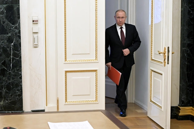Russian President Vladimir Putin enters a hall before a meeting with members of the Security Council via a video link in Moscow on February 25, 2022 [Alexey Nikolsky/Kremlin via Reuters]