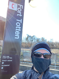 Photo of Jean wearing a mask standing in front of a Fort Totten tower sign