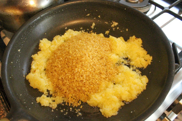 Tip in the bulgur wheat and give the whole thing a good stir so the bulgur is coated with the oil and onions.