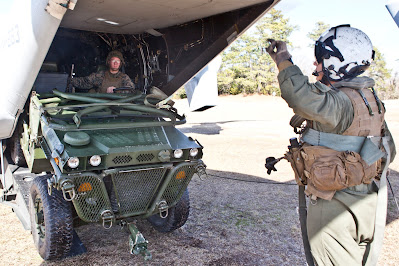 Corporal Saul Ochoa guides Sergeant Trevor R Shepherd driving a M1161 Growler on to a MV22B Osprey at Camp Lejeune North Carolina on the 3rd of February 2015