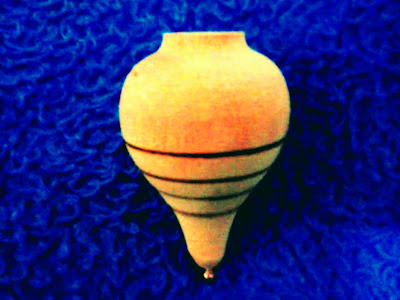 A imagem mostra o pião de madeira um dos brinquedos prediletos das crianças antes da era digital.