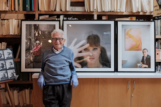 Tony Vaccaro in his stufio with pictures of Calder, Sophia Loren, and Georgia O'Keeffe