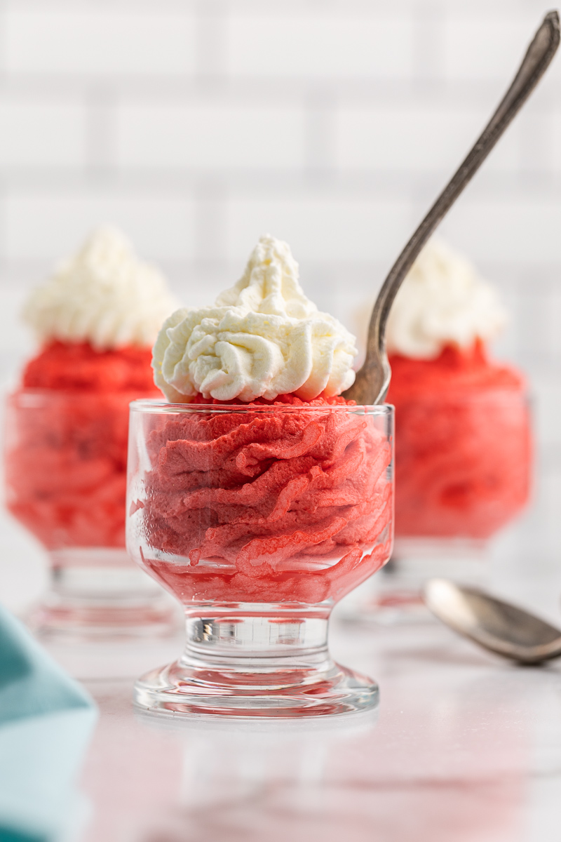 Three glass dessert cups with Keto Red Velvet Mousse and whipped cream.