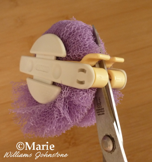 Cut around the middle of the Clover pom pom maker with a very sharp pair of scissors