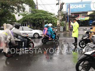 Kenakan Jas Hujan, Polisi Lakukan Pengaturan di Jalan Kusumanegara