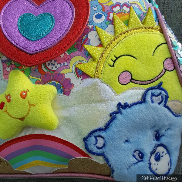 stuffed yellow star, sun and blue Care Bear fur applique on front of bag