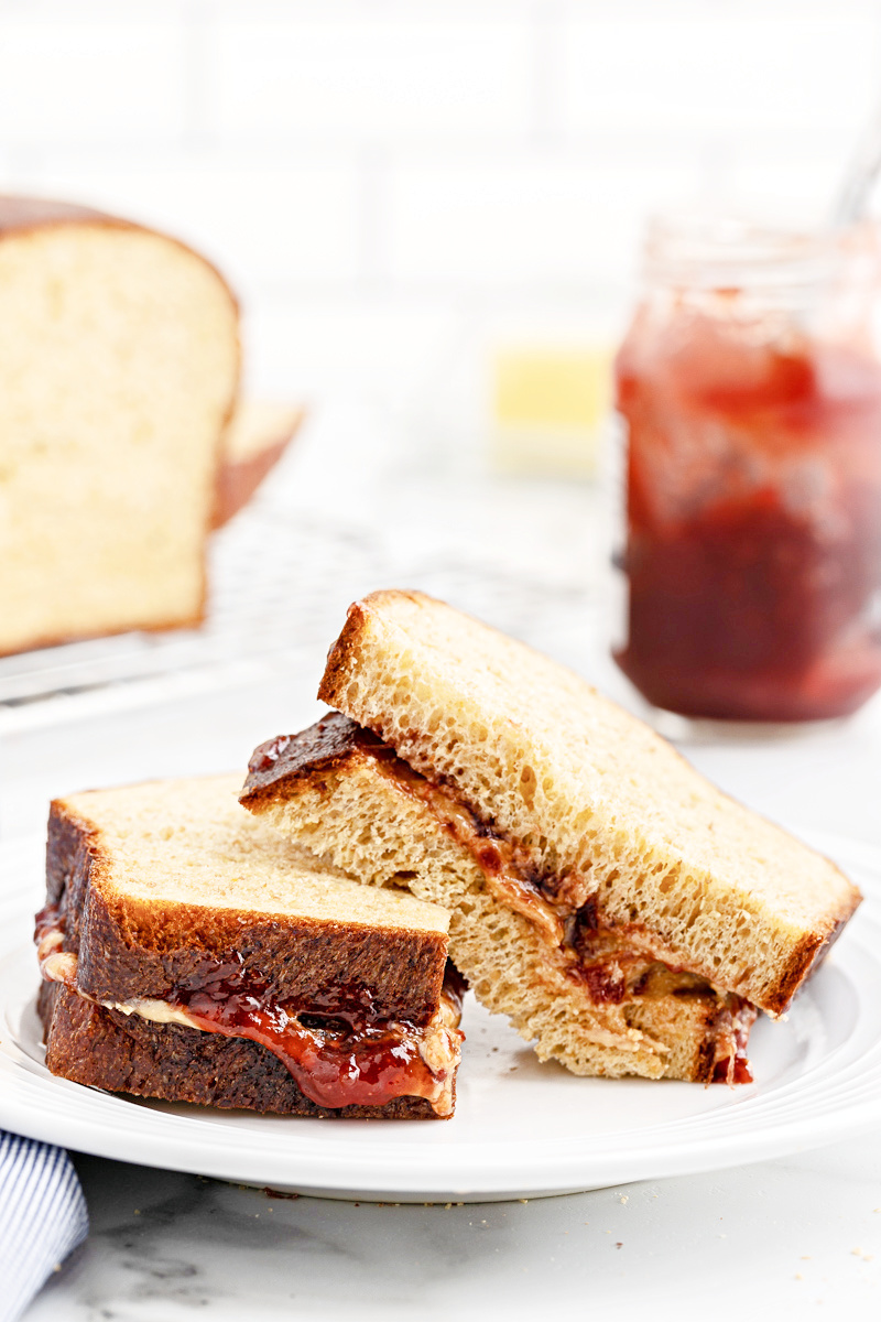 A peanut butter and jelly sandwich made with The BEST Keto Bread (Oven Method) on a white plate.