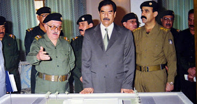 Tariq Aziz (left) and Saddam Hussein (center)