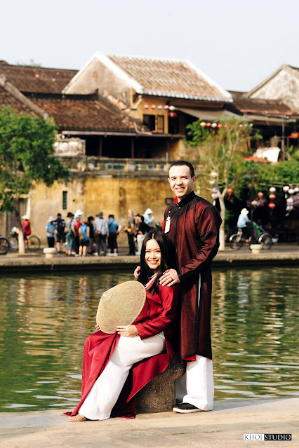 The couple took a travel photo wearing ao dai on the banks of the Hoai River in Hoi An ancient town. Photo: Khoi Studio.