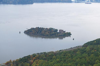 Haunted Bannerman Castle can be seen on the right of Pollepel Island in the Hudson River, New York in this view from atop a nearby mountain.  The rail road line that runs along the eastern shore of the Hudson can be seen in the foreground and offers one of the best views of the castle from the shore.