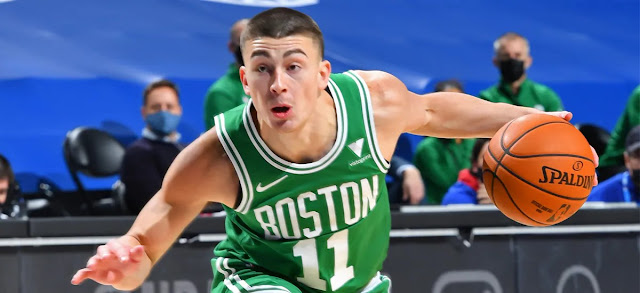 Payton Pritchard in the middle of intensely dribbling a basketball while wearing a green Boston Celtics uniform