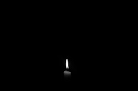 Monochrome image of a lit candle against a uniform dark background.