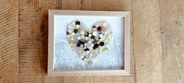 framed button heart on table