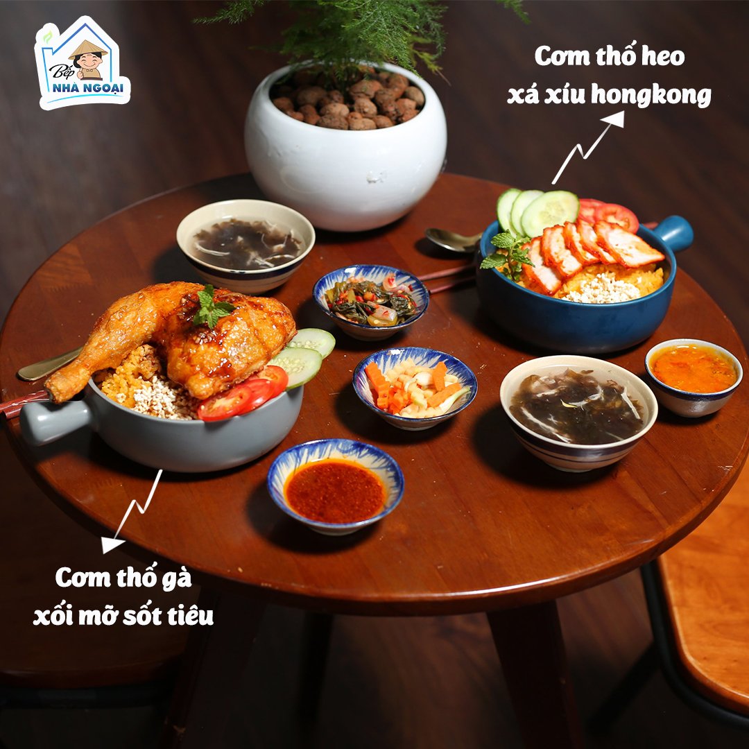Có thể là hình ảnh về thực phẩm và văn bản cho biết 'Bếp NHÀ NGOẠI Cơm thố heo xá xíu hongkong Cơm thố gà xổi mỡ sốt tiêu'