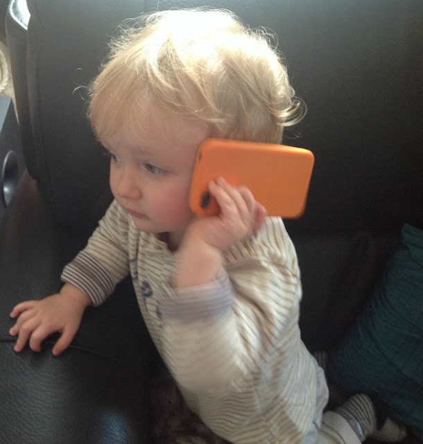 toddler with mobile phone to his ear