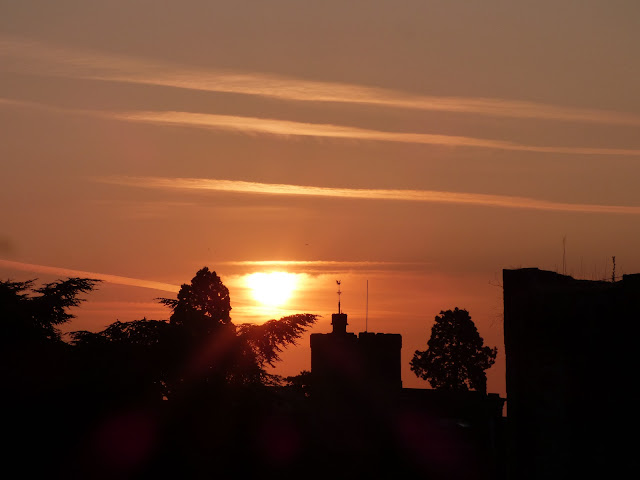 Sunrise at Tonbridge Castle - silhouettes of the castle, Tonbridge Parish Church and trees against an orange backdrop