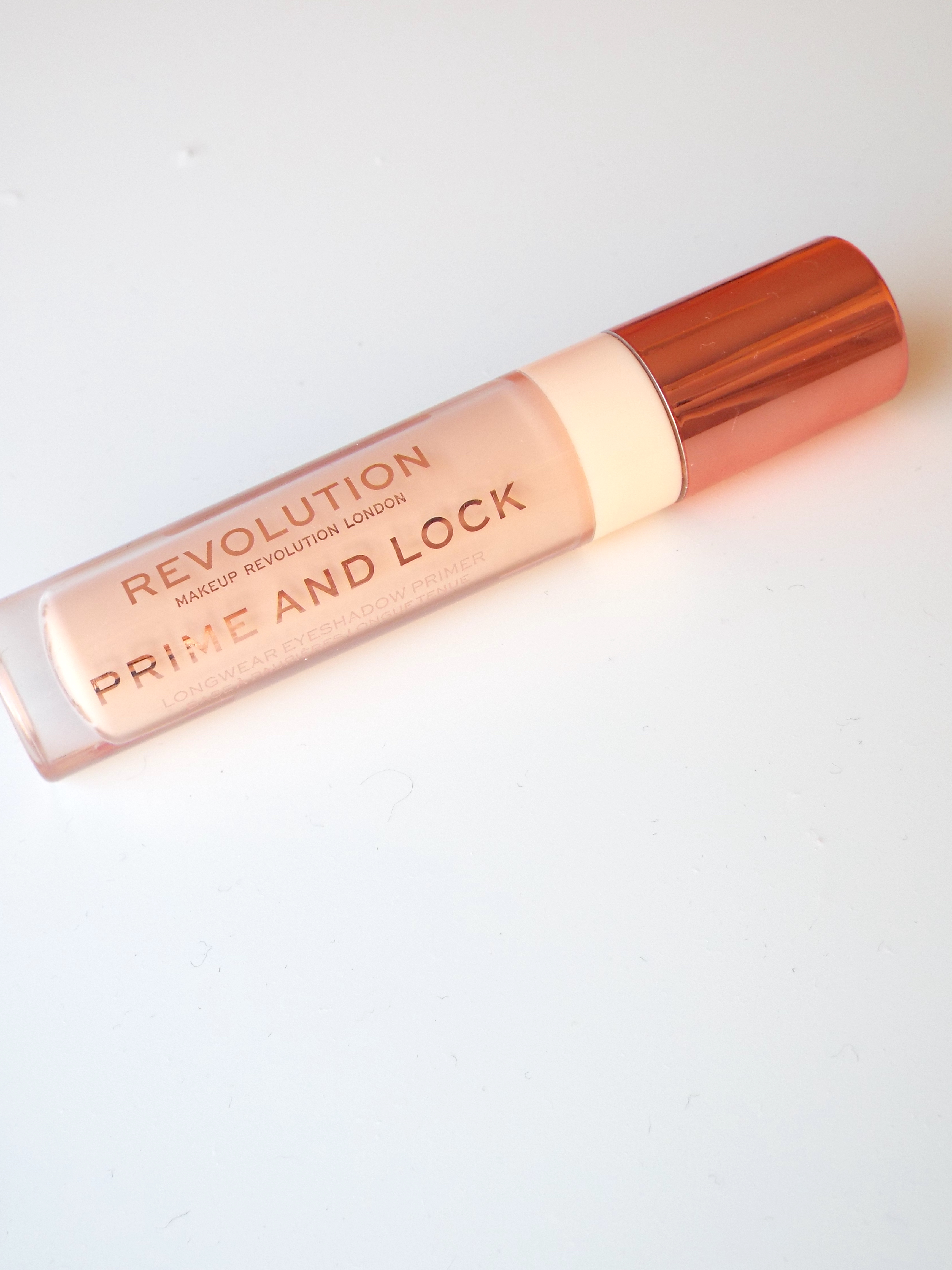 The rose gold packaged Makeup Revolution Prime & Lock Longwear Eyeshadow Primer, on white background.