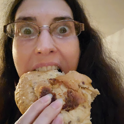 tm wearing glasses and eating a pastry with a wild, horrified expression