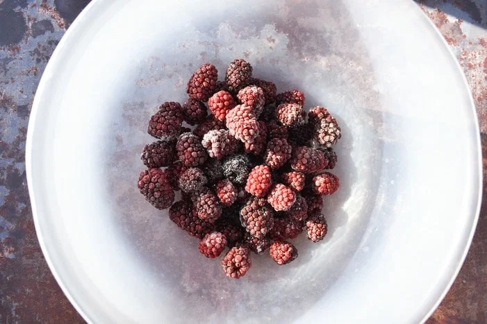 Frozen blackberries in clear bowl