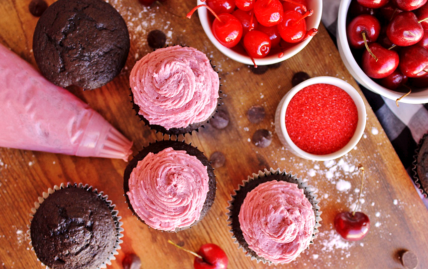 Chocolate Covered Cherry Cupcakes- A Decadent Moist Devil's Food Cake infused with Tart Cherry Juice, topped with a Creamy Tart Cherry Buttercream Frosting, and Drizzled with a Rich Chocolate Ganache.