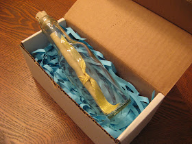 Bottle in box with shredded blue paper