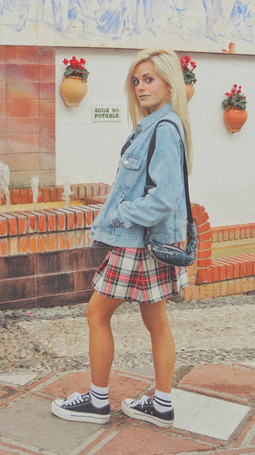 Estilo de los años 90 inspirado en Jennifer Aniston en Friends con suéter blanco, falda de tablas cuadros escoceses, zapatillas y calcetines blancos con raya negra