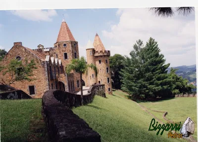 Parede de pedra, com pedra moledo, na cor de pedra avermelhado, na construção de castelo de pedra, com as torres de pedra, os muros de pedra e o pórtico de pedra em sítio em Atibaia-SP.