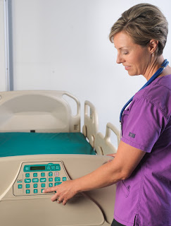 Nurse using a CHG Hospital Beds multi-zone bed-exit alarm