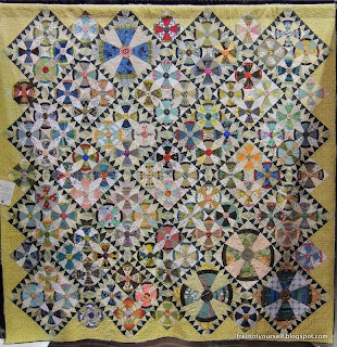 Steam Punk (airplane propeller) quilt blocks grouped in fours with sawtooth sashing of dark blue and white is bordered with chartreuse