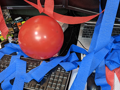 desk covered in balloons and streamers