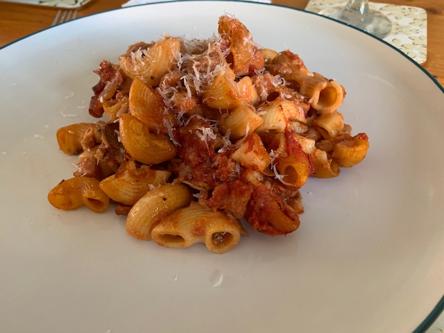 A plate of pasta bake with freshly grated pecorino cheese