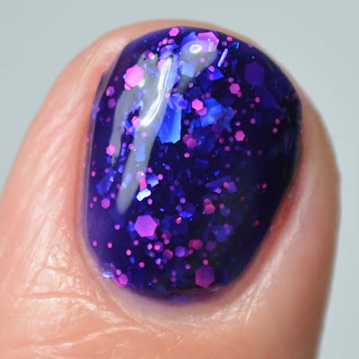 blue nail polish with pink glitter close up swatch