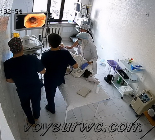 A patient lies on their side while a gastroenterologist inserts a colonoscope (Female colonoscopy SpyCam 45-47)