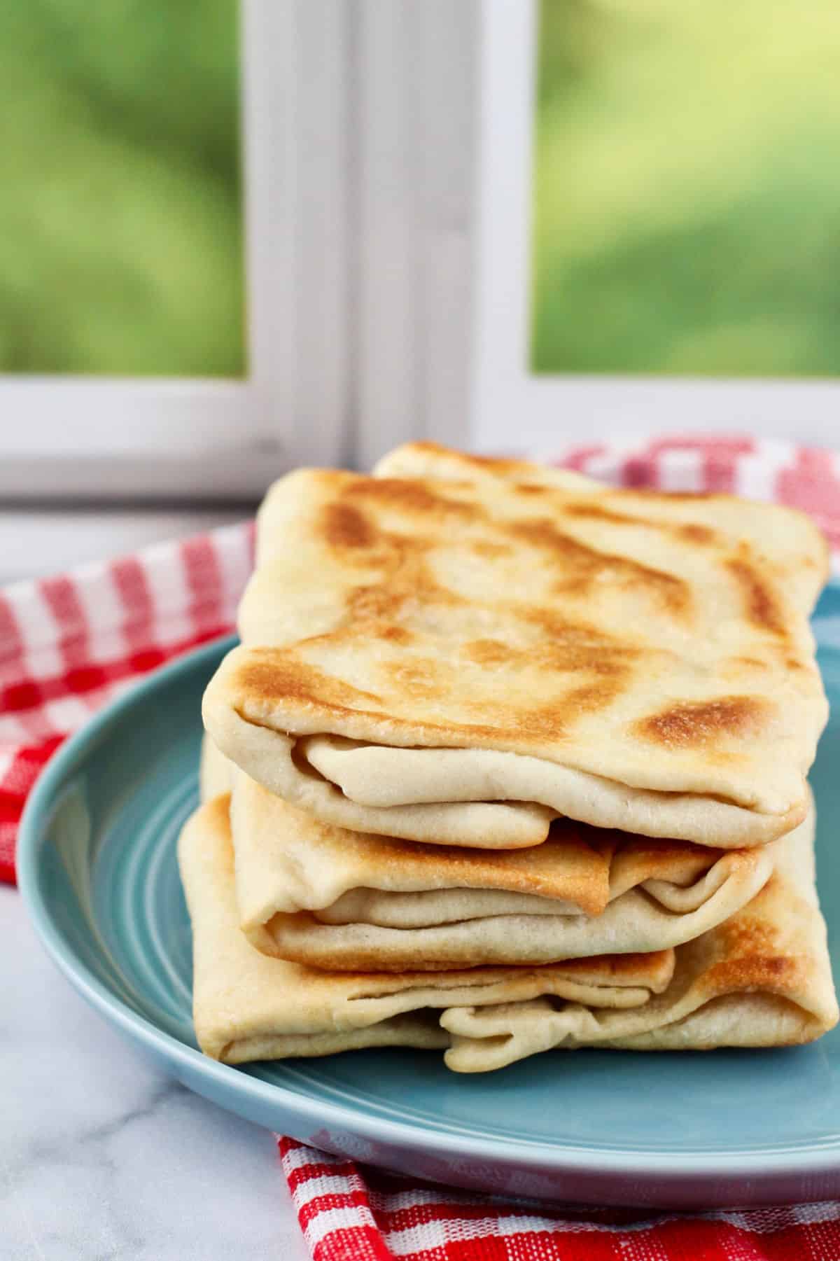 Rgaif - Moroccan Flat Bread stacked on a plate.