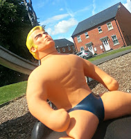 Stretch Armstrong seated on a swing