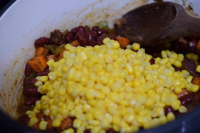 The corn being added to the dutch oven.