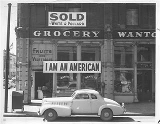 A large sign reading "I am an American" placed in the window of a store, at 13th and Franklin streets, on December 8, the day after Pearl Harbor. The store was closed following orders to persons of Japanese descent to evacuate from certain West Coast areas. The owner, a University of California graduate, will be housed with hundreds of evacuees in War Relocation Authority centers for the duration of the war.