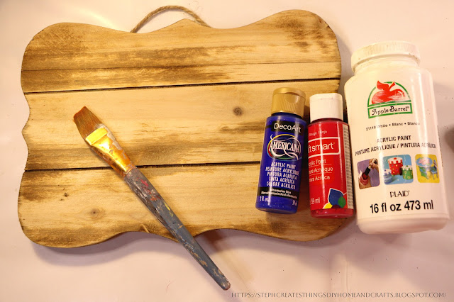 Wooden sign with with paintbrush and acrylic paint on a table