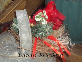 Red Bird Perched on a Nest on the Opening of the Watering Can
