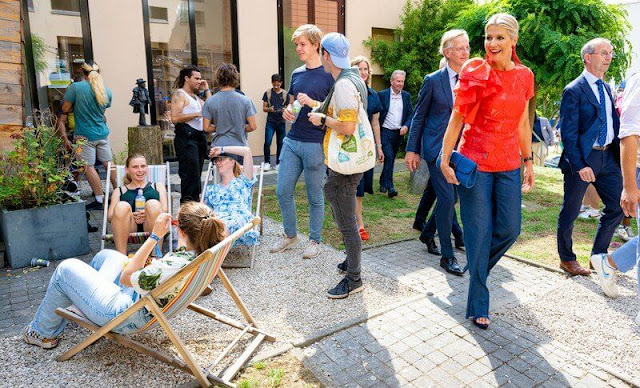 Queen Maxima wore a Natan embroidered floral top, and Natan navy denim trousers, Miu Miu navy leather sandals, Miccy's earrings