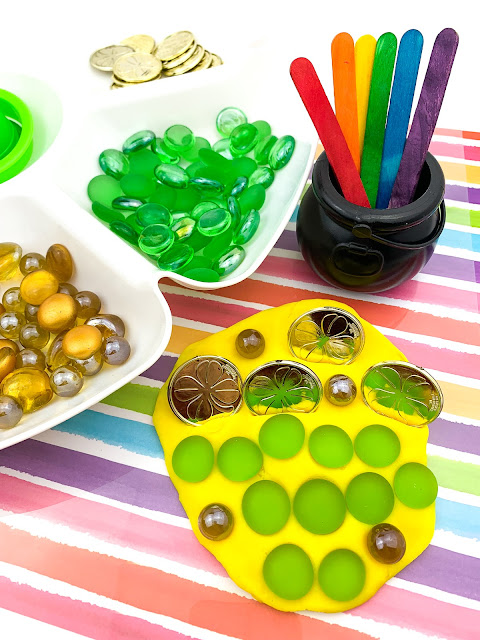 gems and coins stuck into yellow play dough.