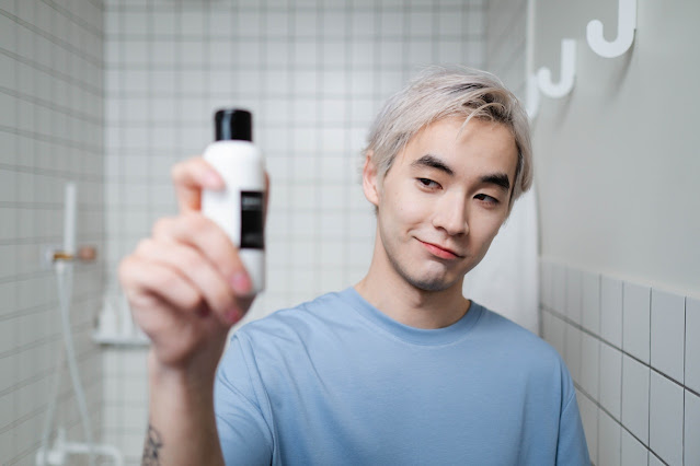 man-in-blue-crew-neck-shirt-holding-white-and-black-bottle