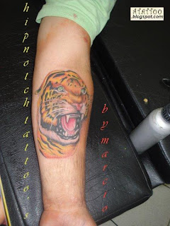 Tigre tatuado no ante-braço.