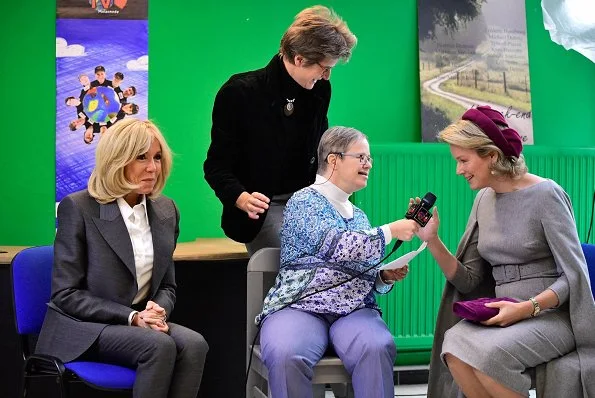 President Emmanuel Macron. First Lady Brigitte Macron is waring grey suit, and Queen Mathilde wore Merino wool cape dress