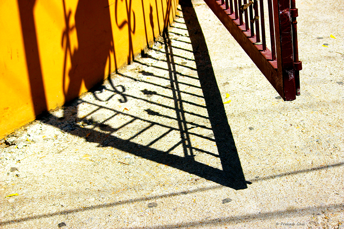 A minimalist photo of the Shadow of a Gate partially open