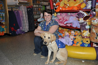 Me sitting next to plush mountain in the disney store, Bob is sitting next to me looking towards the camera