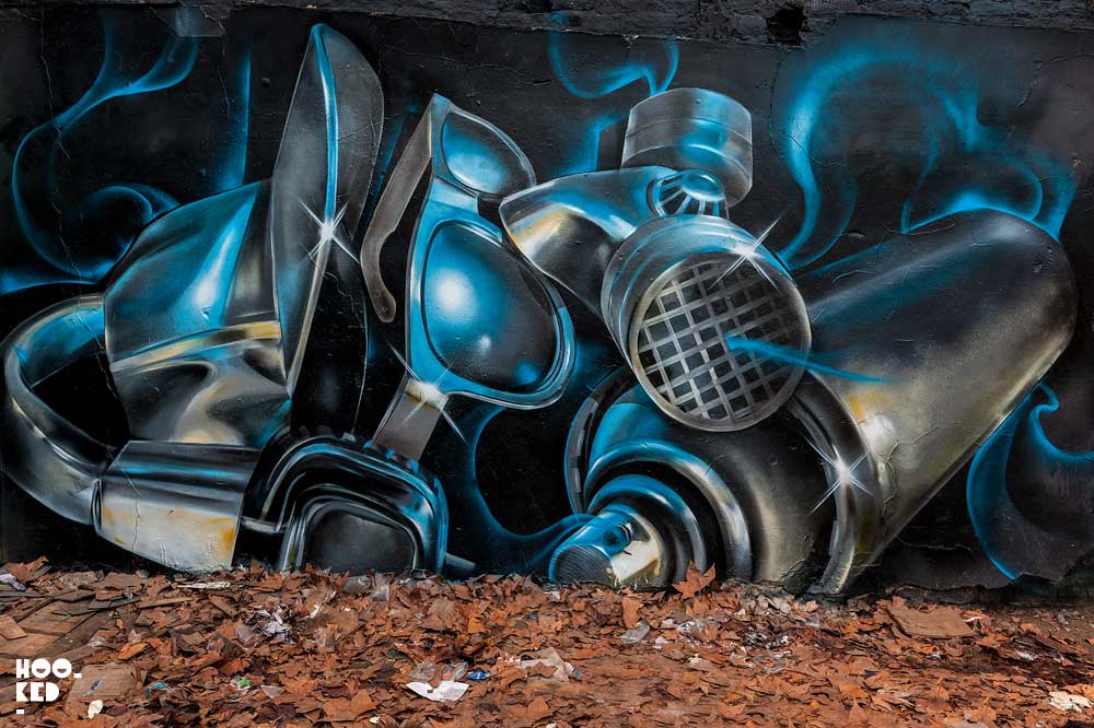 London street artist Fanakapan paints a mural in East London's Seven Star Yard car park.