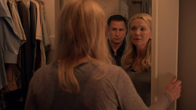 Stephen King's A Good Marriage 2014 movie still showing Anthony LaPaglia standing menacingly behind Joan Allen as she looks at him in the mirror