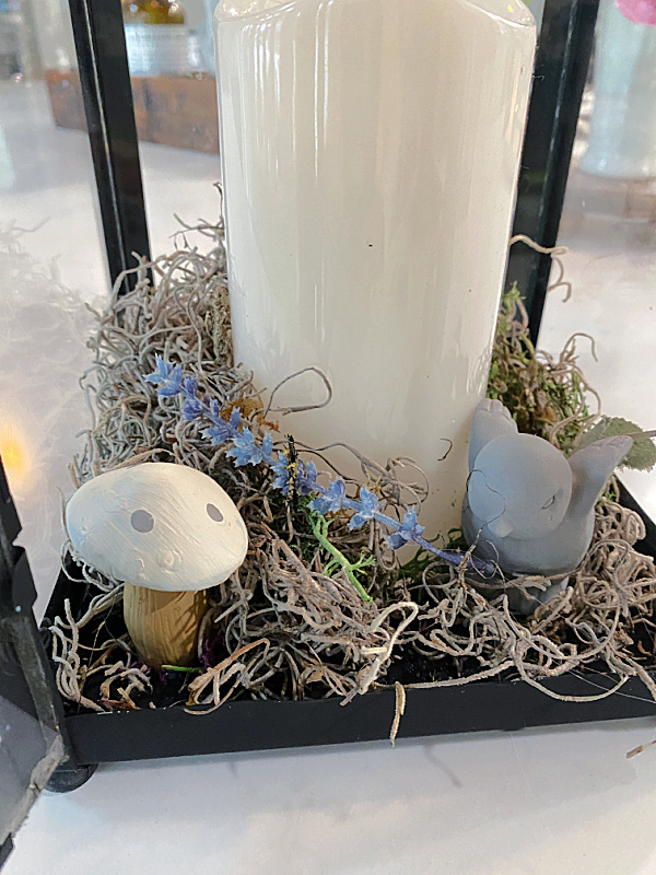 lantern with bird and mushroom in moss